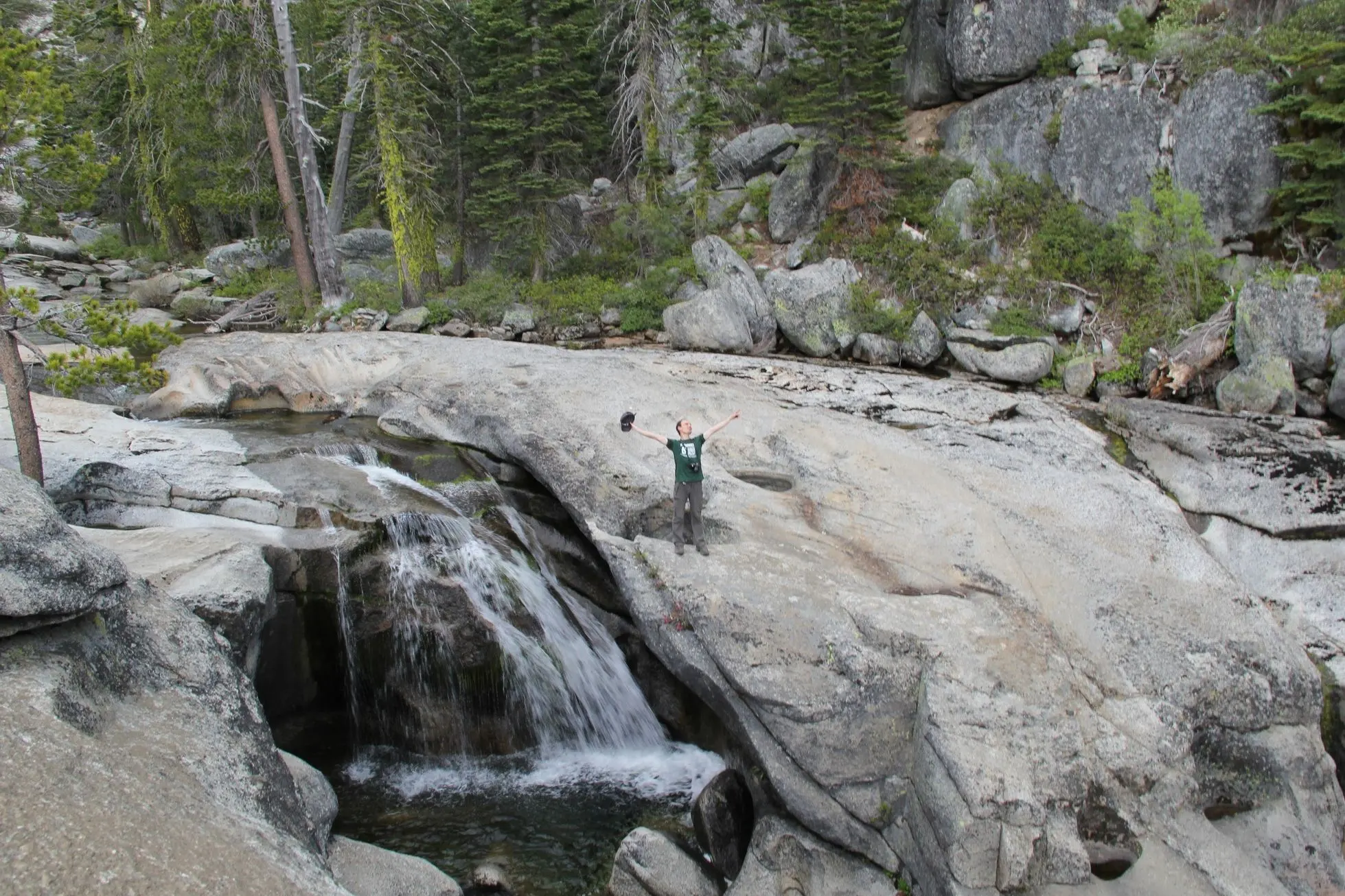 On the rocks next to a small waterfall